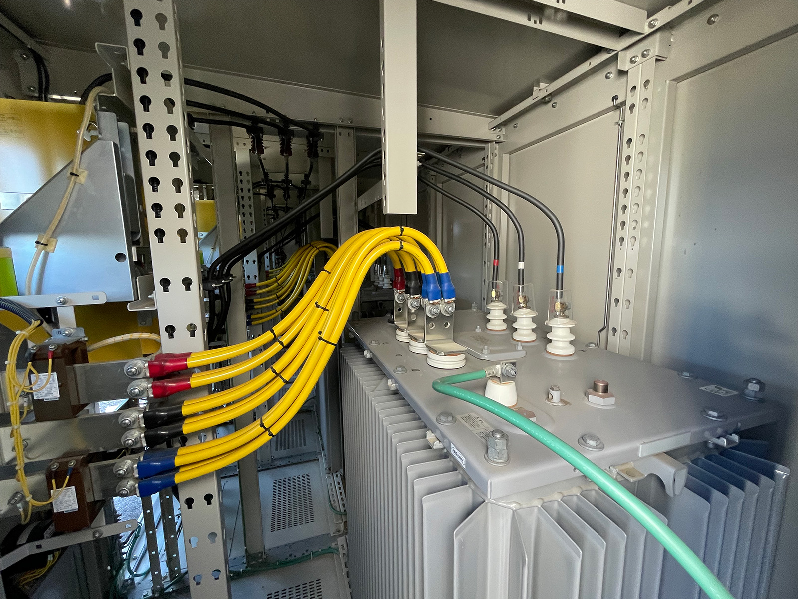 6.6kV高圧受電から変圧器を通じて400V・200V・100Vの負荷へ供給される受変電設備と、トップランナー基準、老朽化、酷暑、遠隔監視を示すイメージ