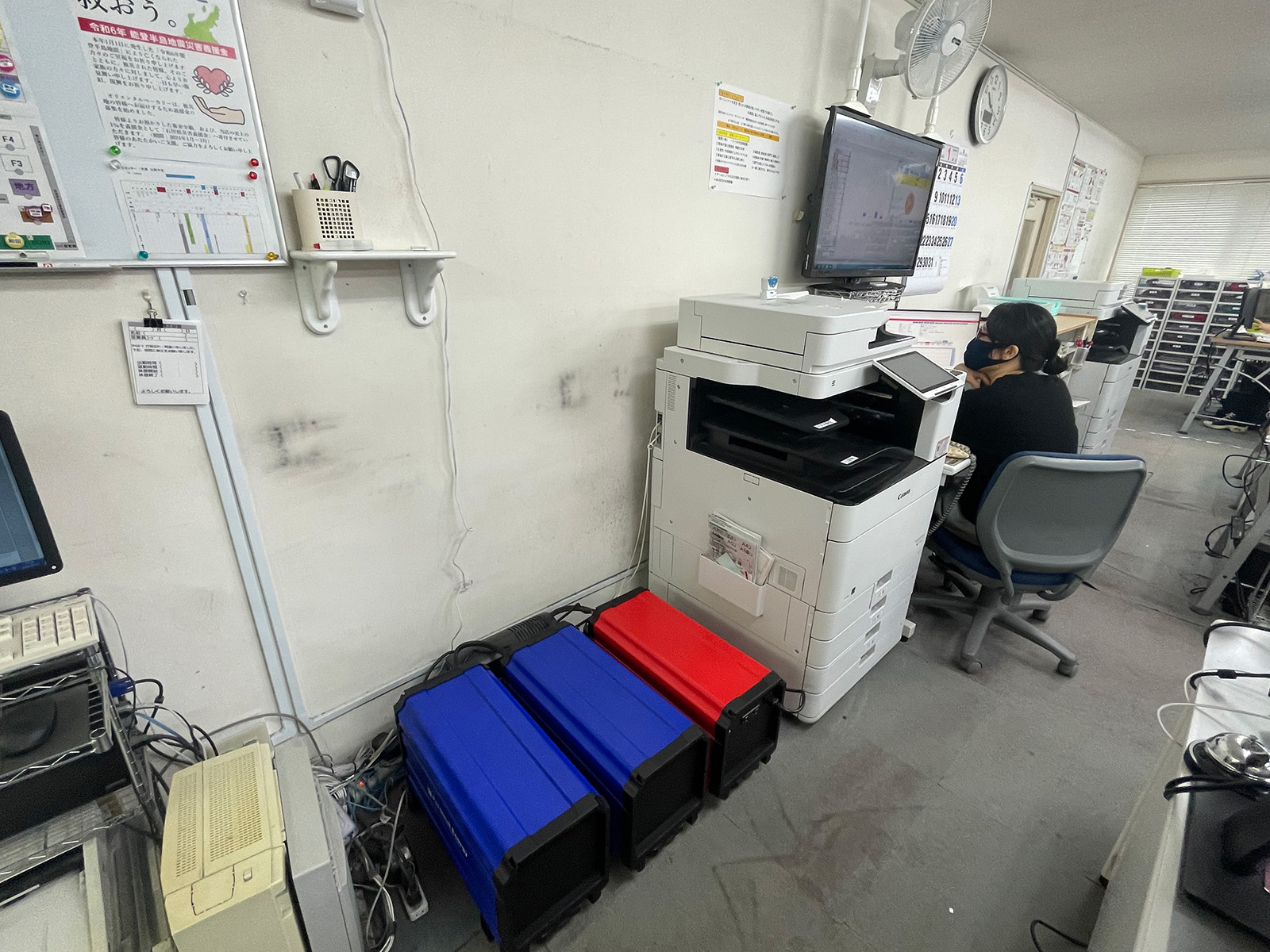 複合機のそばに設置された可搬型UPSと増設バッテリー